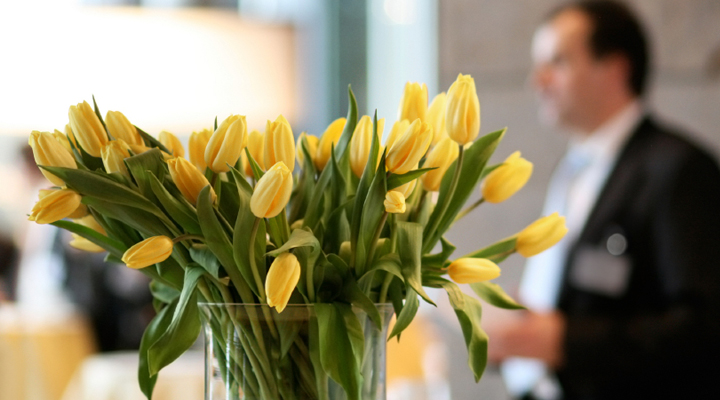 Eine Vase mit vielen leuchtenden gelben Tulpen an einer Hotelrezeption